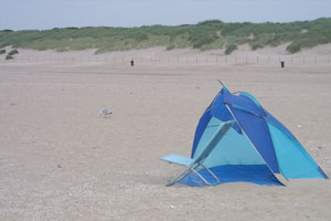 Blauw strandtentje met blauw klapstoeltje op het strand